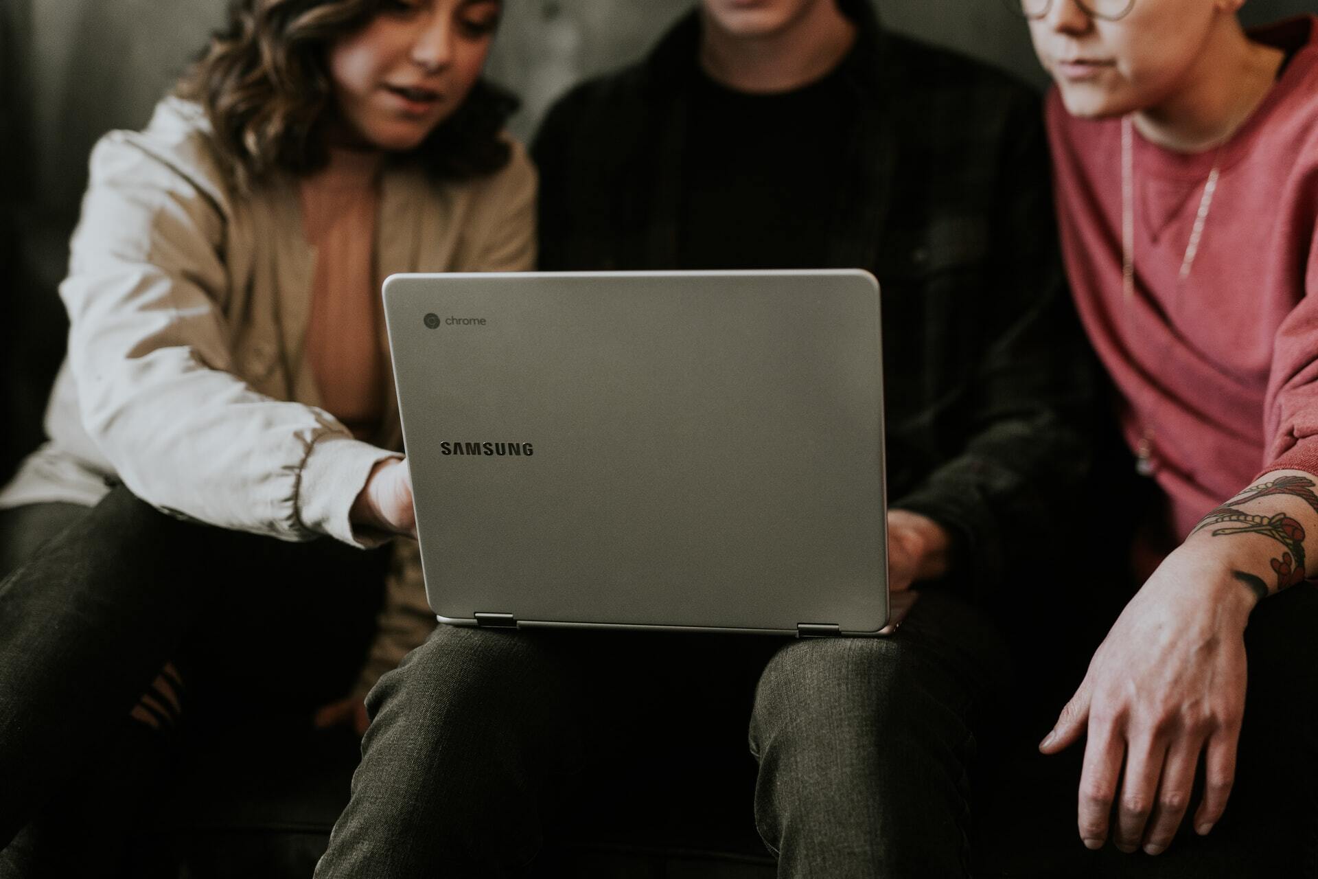 three people looking at laptop together