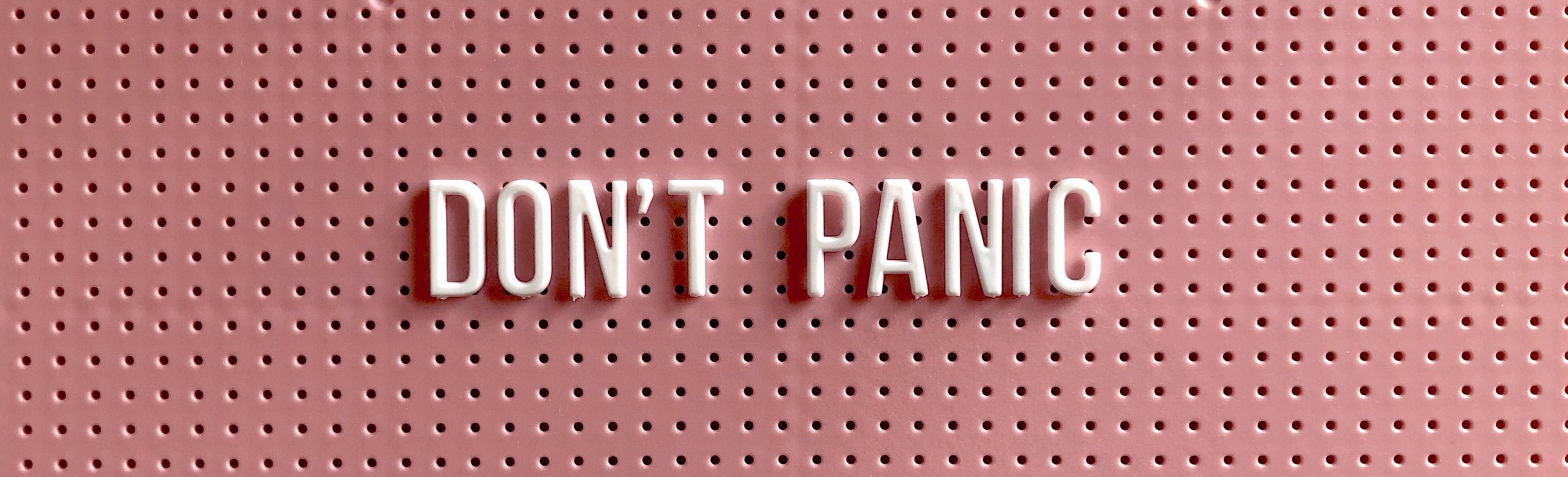 don't panic spelled out on a pin board